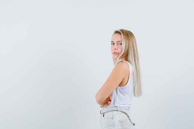 Señorita en blusa blanca mirando a un lado y mirando seria. espacio para texto