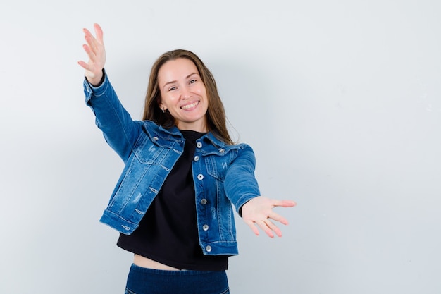 Foto gratuita señorita en blusa, chaqueta abriendo los brazos para abrazar y mirando alegre, vista frontal.