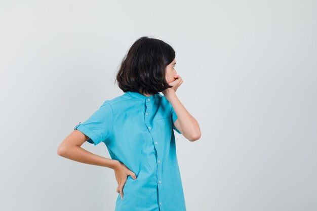 Señorita con camisa azul mirando hacia atrás y mirando preocupado.