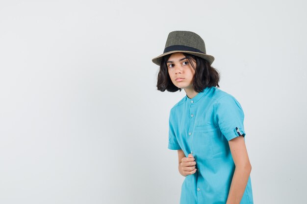Señorita con camisa azul, sombrero mirando a otro lado y mirando emocionado