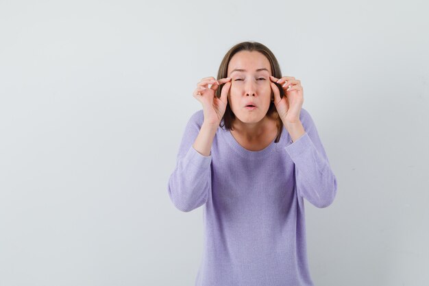 Señorita en camisa casual fingiendo hacer maquillaje y con aspecto divertido