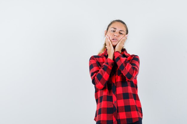 Señorita en camisa a cuadros que sufre de dolor de muelas y se ve incómodo