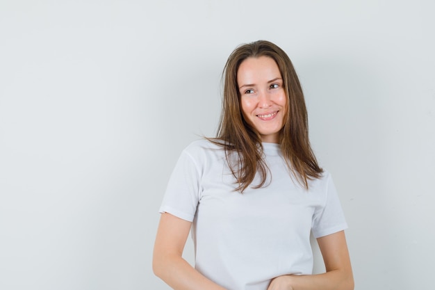 Señorita en camiseta blanca mirando a otro lado y mirando encantador