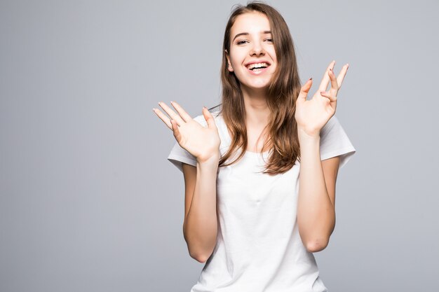 Señorita en camiseta blanca y pantalones vaqueros azules permanecer delante de fondo blanco de estudio