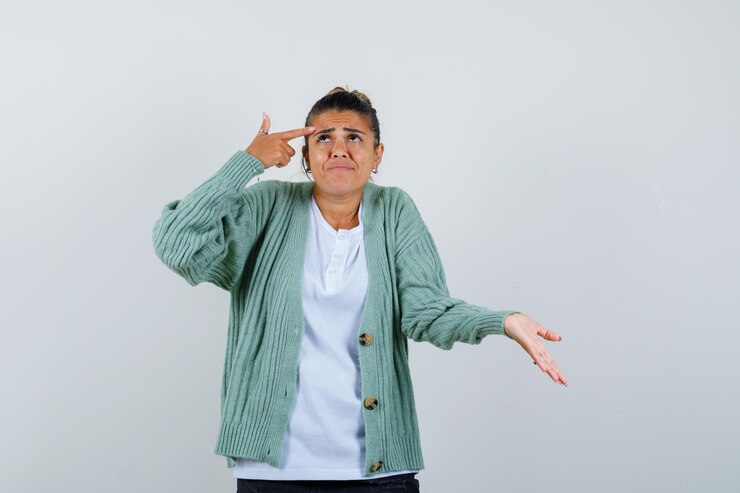 Foto gratuito señorita en camiseta, chaqueta apuntando a la cabeza y mirando pensativo