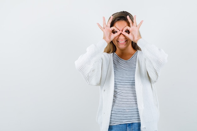 Foto gratuita señorita en camiseta, chaqueta mostrando gesto de gafas y mirando alegre, vista frontal.