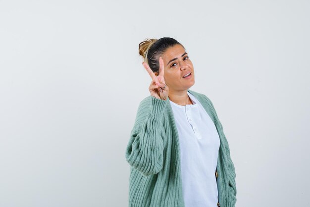 Señorita en camiseta, chaqueta mostrando el signo de la victoria y con suerte