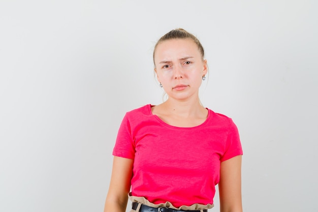 Señorita en camiseta rosa y mirando triste