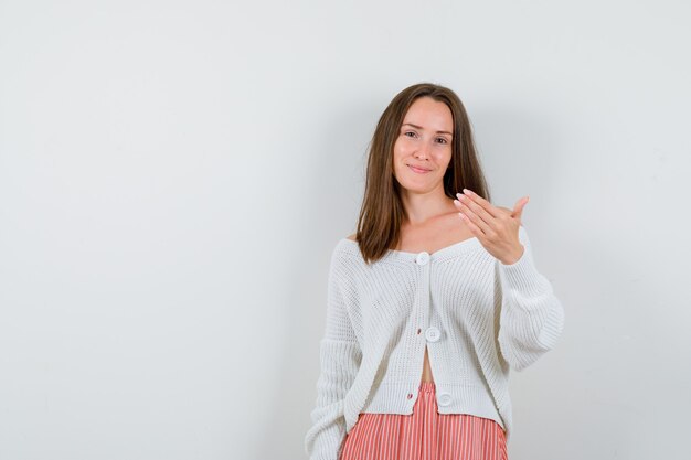 Señorita en chaqueta de punto y falda invitando a venir luciendo lindo aislado