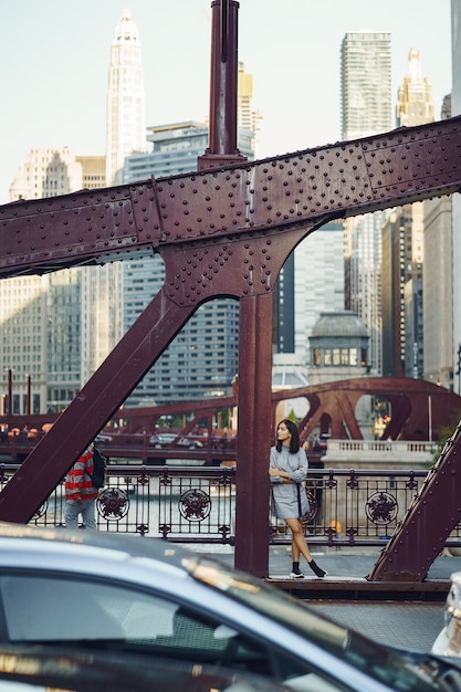 señorita cruzando el puente de la ciudad