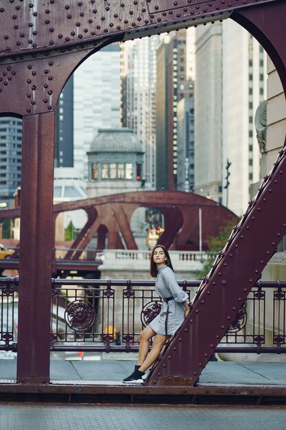 señorita cruzando el puente de la ciudad