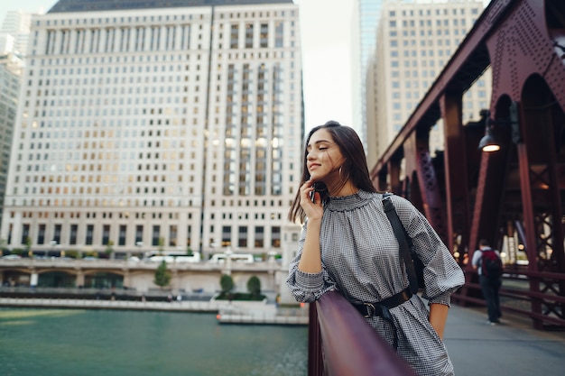 señorita cruzando el puente de la ciudad