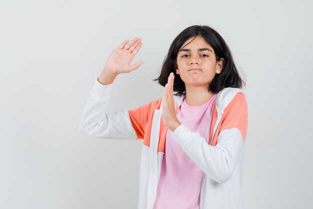 Señorita defendiendo con sus brazos en chaqueta, camisa rosa y luciendo poderosa.