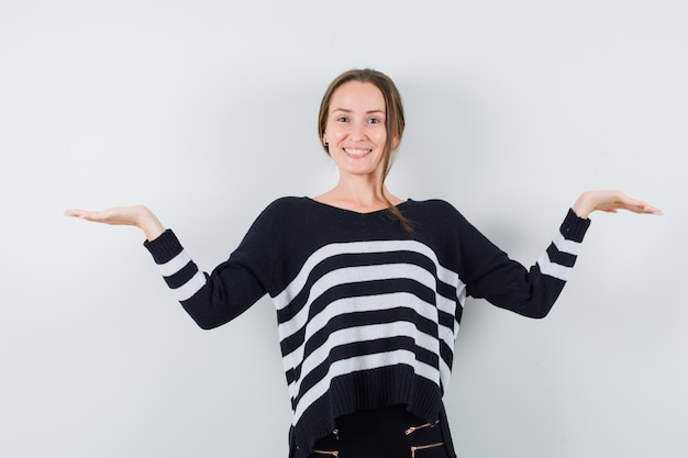 Señorita haciendo gesto de escalas en camisa casual y mirando feliz