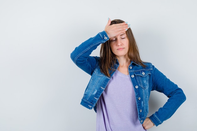 Foto gratuita señorita manteniendo la mano en la frente, cerrando los ojos en camiseta, chaqueta y con aspecto cansado, vista frontal.