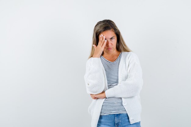 Señorita manteniendo la mano sobre la cabeza en camiseta, chaqueta y mirando frustrado, vista frontal.