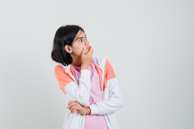 Señorita mirando a un lado mientras en chaqueta, camisa rosa y mirando asustada.