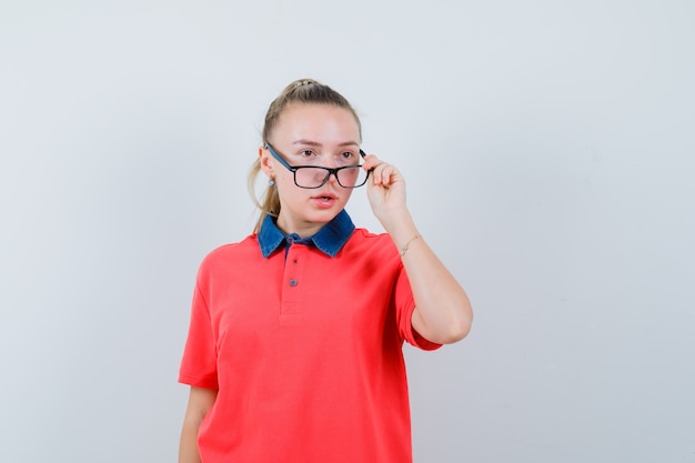 Señorita mirando a otro lado sobre gafas en camiseta y mirando desconcertado