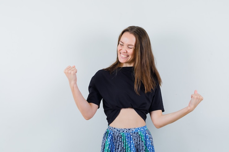 Foto gratuito señorita mostrando gesto ganador en blusa, falda y con suerte