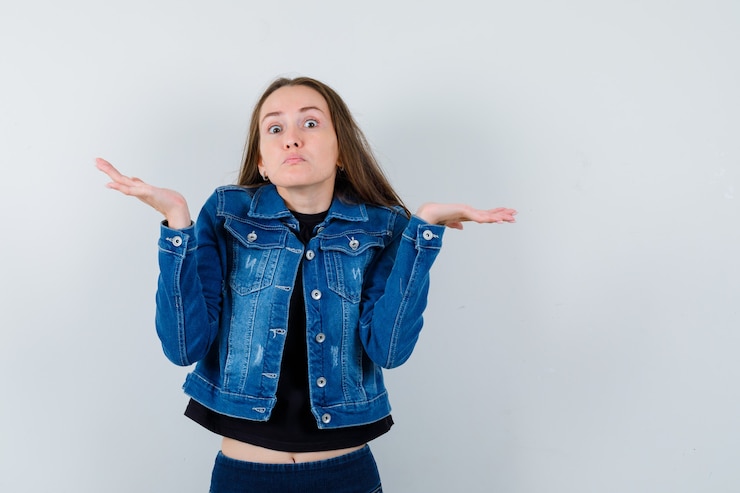 Foto gratuito señorita mostrando gesto de impotencia en blusa, chaqueta y mirando confundido, vista frontal.