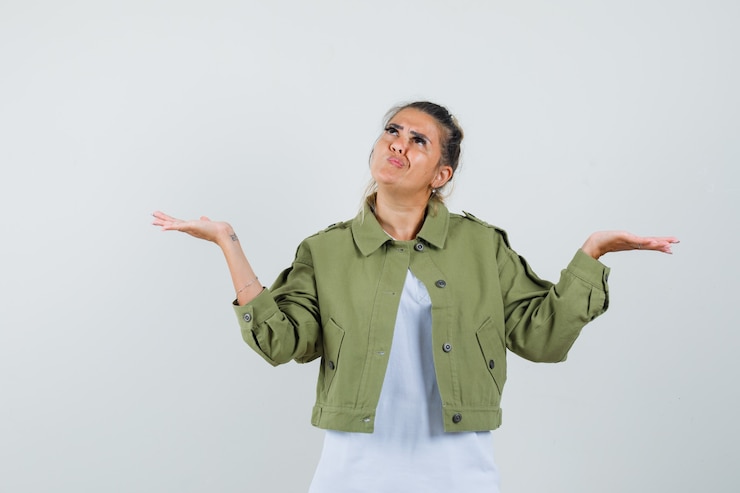 Foto gratuito señorita mostrando un gesto de impotencia en la chaqueta de la camiseta y mirando confundido