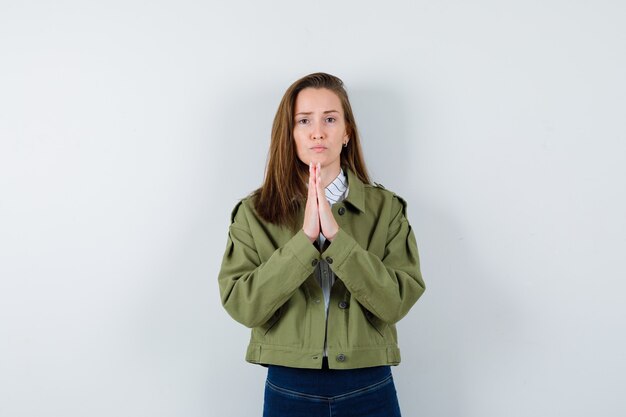 Señorita mostrando gesto de namaste en camisa, chaqueta y mirando esperanzado, vista frontal.