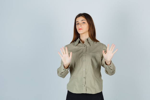 Señorita mostrando gesto de rechazo en camisa, falda y aspecto serio. vista frontal.