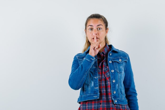 Foto gratuita señorita mostrando gesto de silencio en camisa, chaqueta y mirando con cuidado, vista frontal.