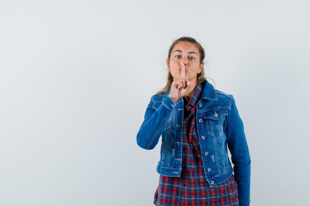 Foto gratuita señorita mostrando gesto de silencio en camisa, chaqueta y mirando lindo, vista frontal.