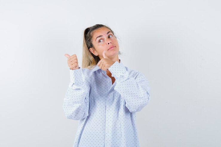 Foto gratuito señorita mostrando los pulgares para arriba en camisa y luciendo linda