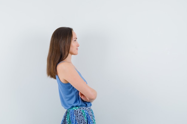 Foto gratuita señorita de pie con los brazos cruzados en blusa, falda.