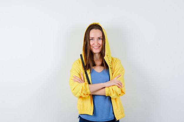 Señorita de pie con los brazos cruzados en camiseta, chaqueta y aspecto sensato. vista frontal.