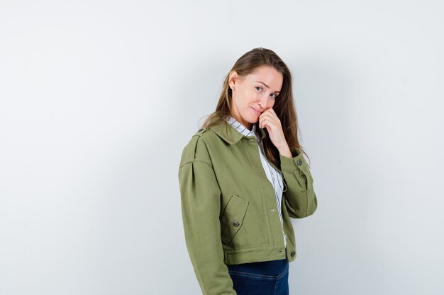 Señorita de pie en pose de pensamiento en blusa y mirando sensible