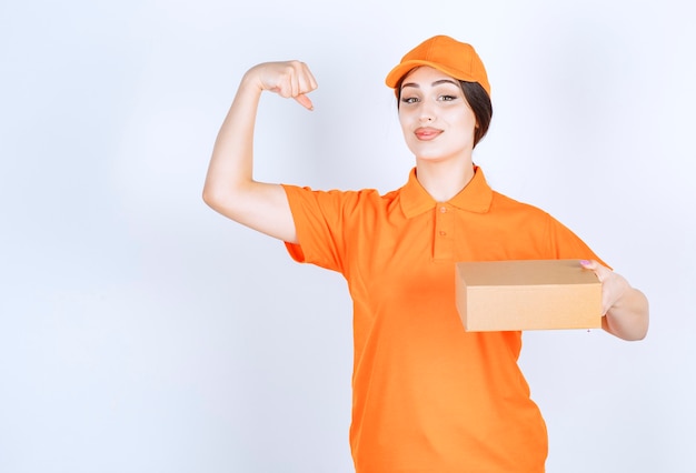 Señorita poderosa. Joven mujer de entrega en la pared blanca