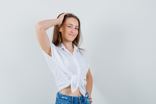 Señorita posando en blusa blanca y aspecto encantador. vista frontal.