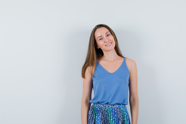 Señorita posando mientras está de pie en camiseta, falda y bonita