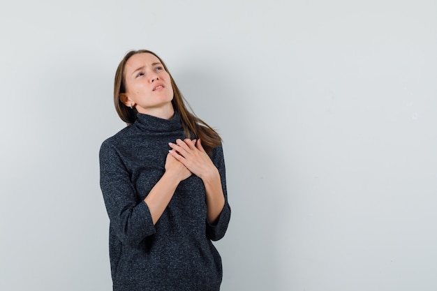 Señorita que sufre de dolor en el corazón en camisa y se ve mal