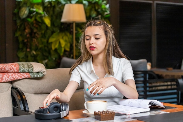 Señorita sentada en el restaurante y tomando sus auriculares