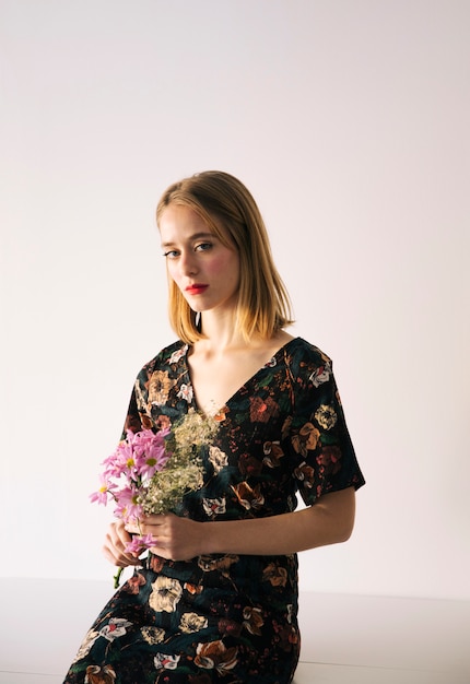 Sensual encantadora joven con ramo de flores y plantas