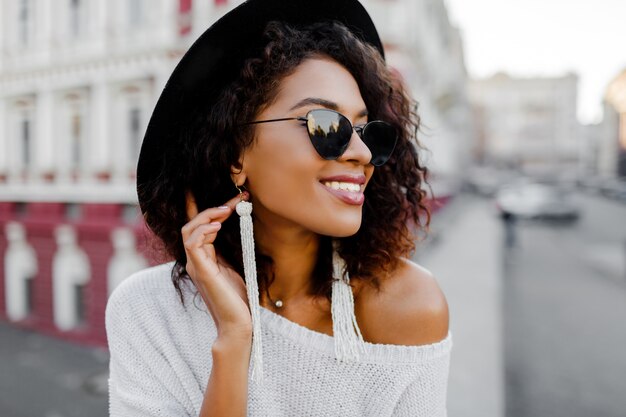 Sensual mujer africana en traje de moda disfrutando de un buen día