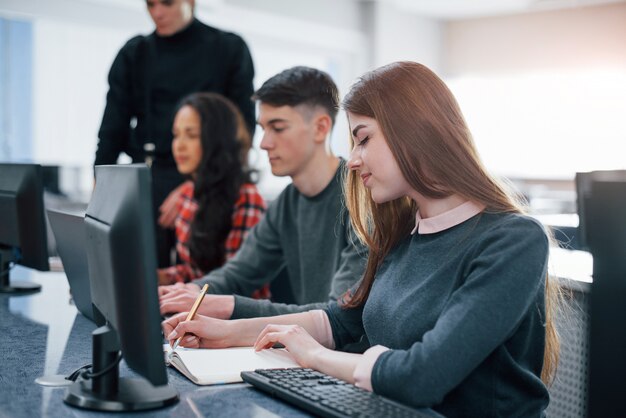 Sentirse bien. Grupo de jóvenes en ropa casual que trabajan en la oficina moderna