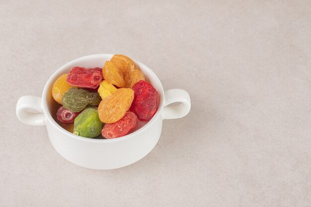 Seque las cerezas de colores en una taza de cerámica.