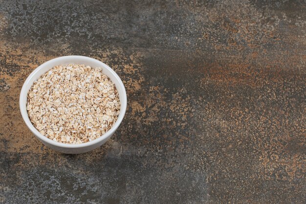 Seque las hojuelas de avena en un tazón blanco.