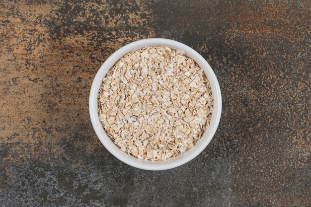 Seque las hojuelas de avena en un tazón blanco.