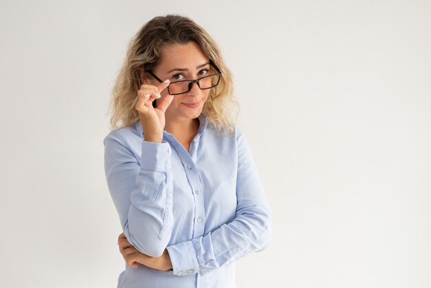 Seria dama de negocios snippy mirando por encima de sus gafas