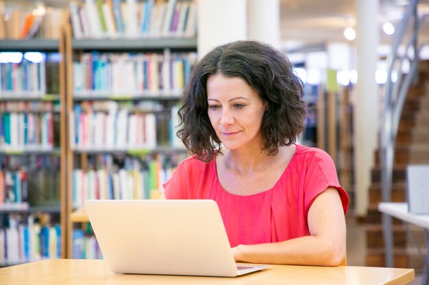 Seria mujer excitada trabajando en la computadora
