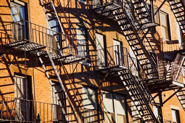 Serie de escaleras de escape en caso de incendio en la fachada de un edificio de apartamentos de ladrillo en la ciudad