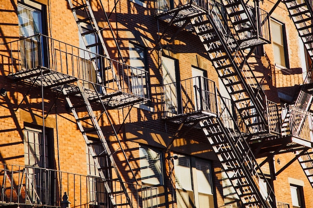 Serie de escaleras de escape en caso de incendio en la fachada de un edificio de apartamentos de ladrillo en la ciudad