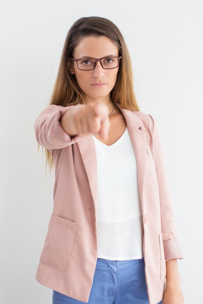 Foto gratuita serio joven empresaria apuntando a la cámara