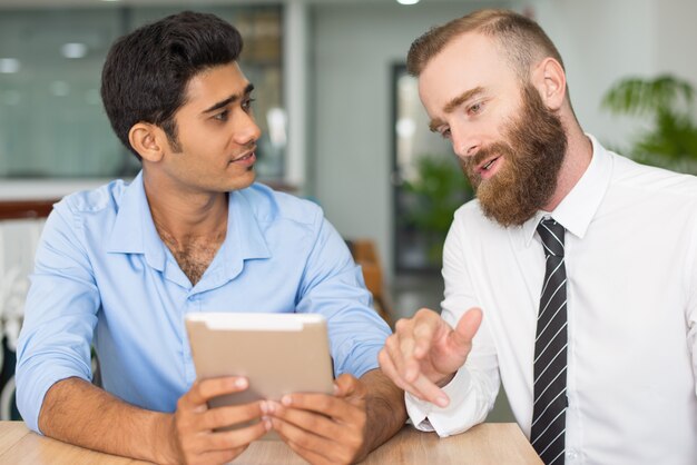 Serios profesionales creativos estudiando proyecto.